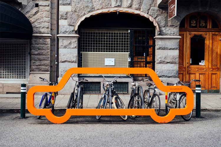Eye-catching car signage fixed to public bike parking racks located on a city street