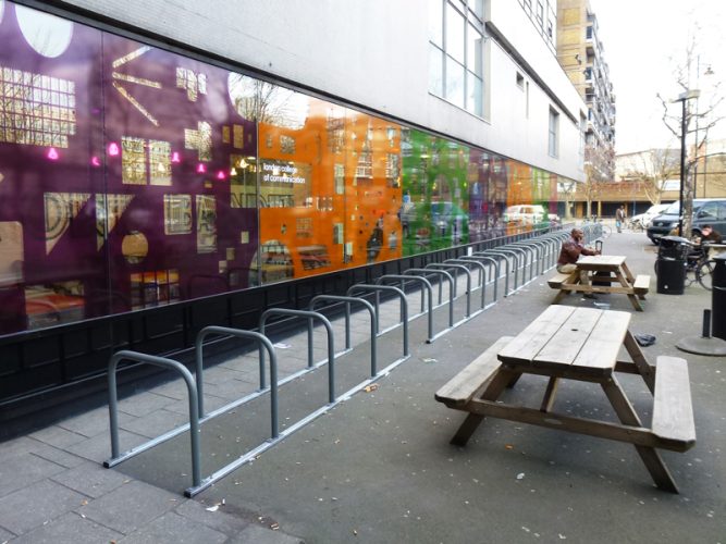 Toast racks extend across the front of a building to provide parking for cyclists