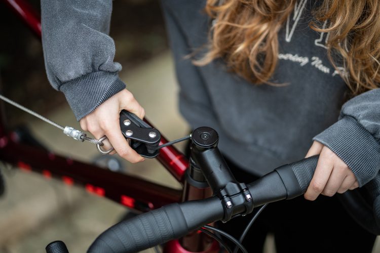 Cyclist using the Cyclehoop Deluxe Bike Repair Station to adjust their handlebar