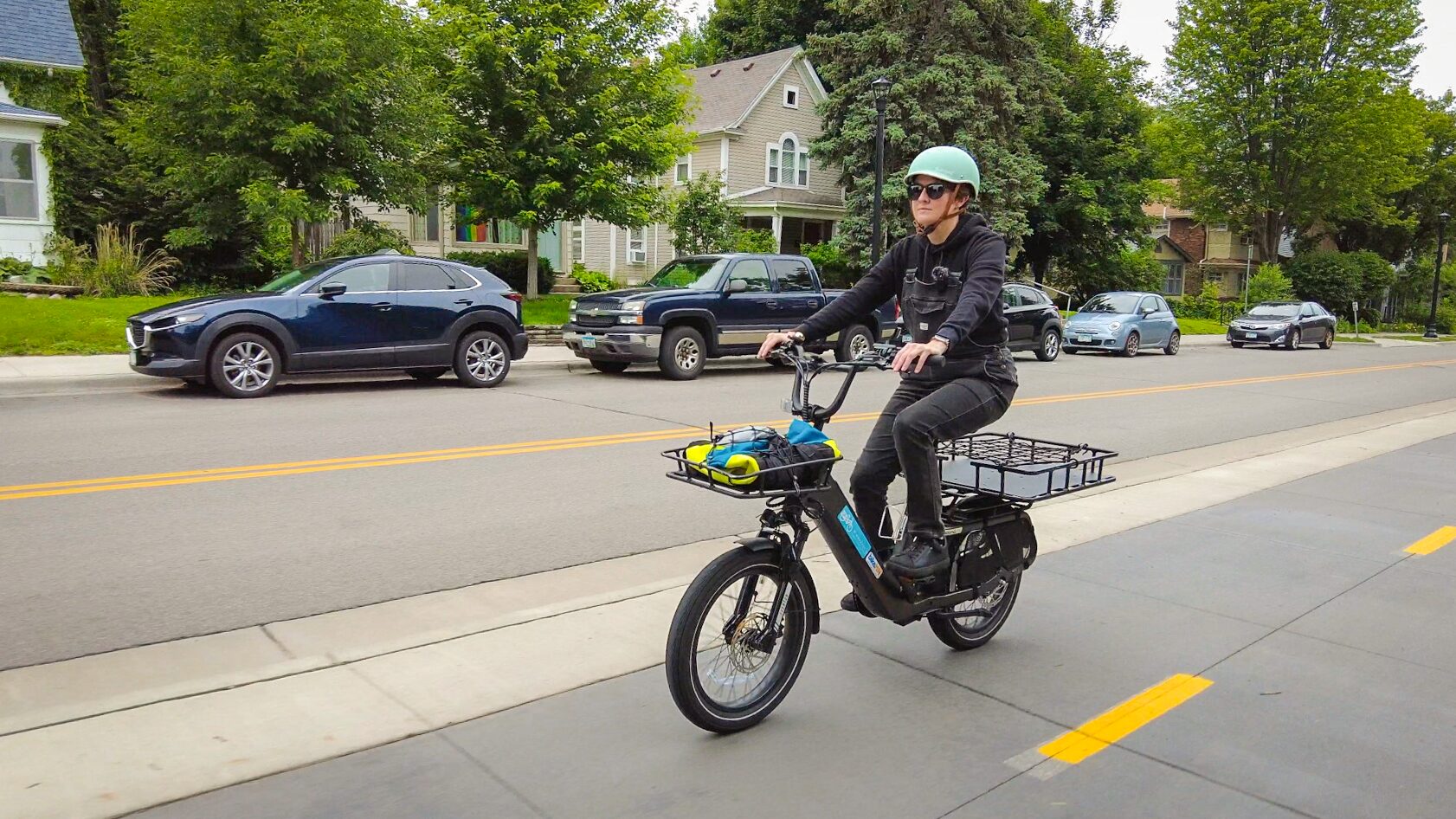 A woman riding a cargo bike from the Minneapolis Cargo Bike Library